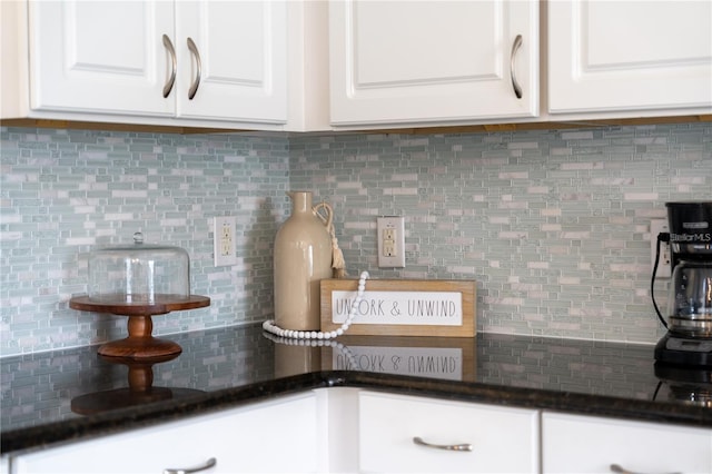 interior details with decorative backsplash and white cabinetry