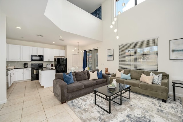 tiled living room featuring a towering ceiling and an inviting chandelier