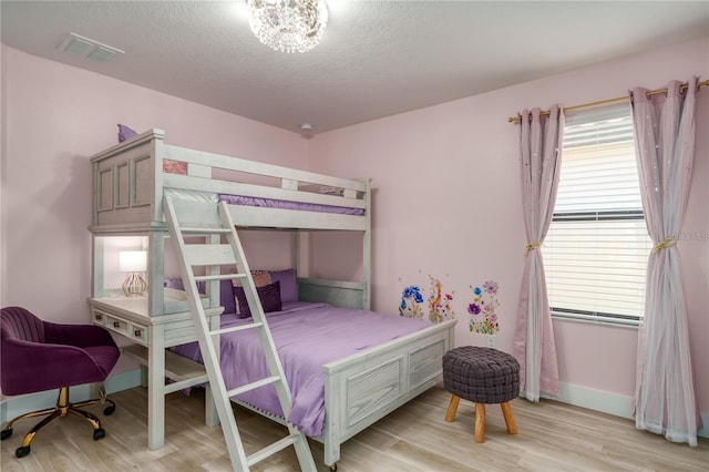 bedroom with a textured ceiling and light wood-type flooring