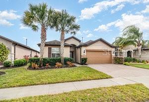 single story home with a garage and a front lawn