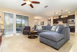 living room featuring ceiling fan with notable chandelier