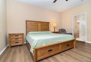 bedroom featuring hardwood / wood-style floors, ceiling fan, and ensuite bathroom