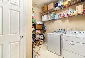 washroom with light tile patterned flooring and independent washer and dryer