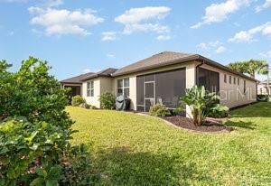 back of property featuring a sunroom and a lawn