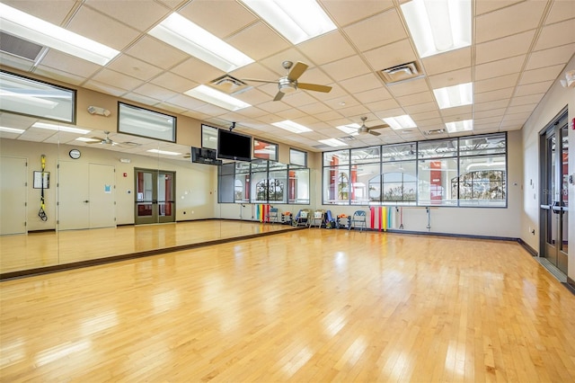 exercise room featuring hardwood / wood-style floors, ceiling fan, and a paneled ceiling