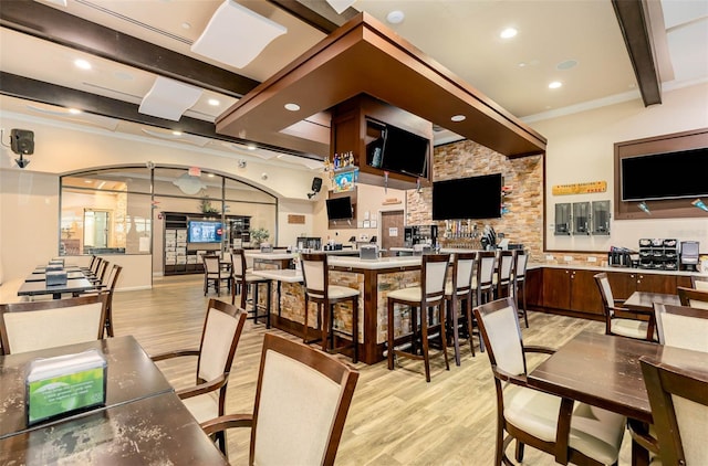 dining space featuring beam ceiling, light hardwood / wood-style flooring, and ornamental molding