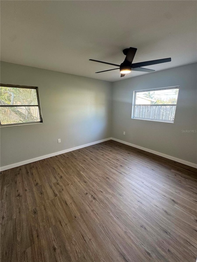 empty room with a healthy amount of sunlight and dark wood-type flooring