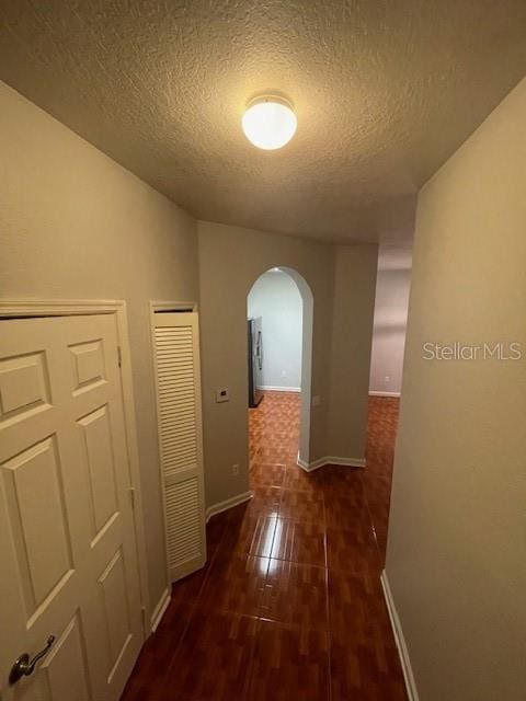 hall featuring a textured ceiling