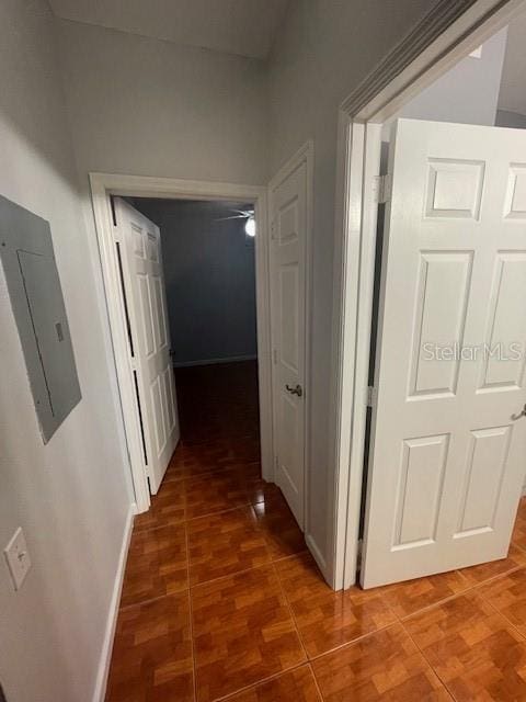 hall featuring electric panel and dark tile patterned floors