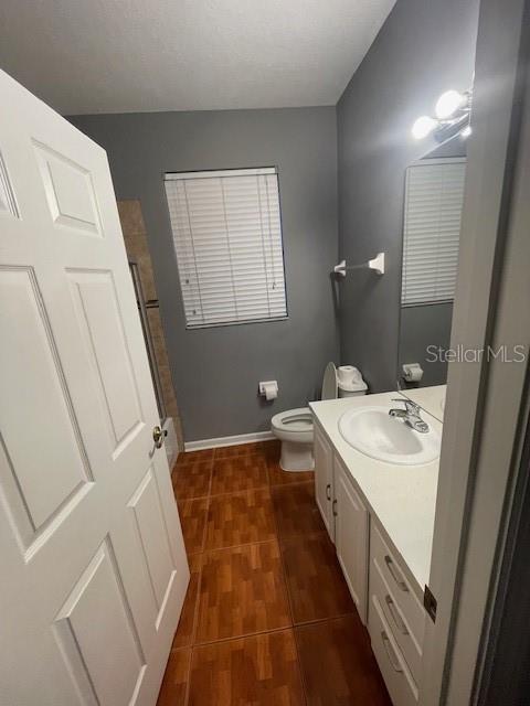 bathroom with vanity, toilet, and hardwood / wood-style floors