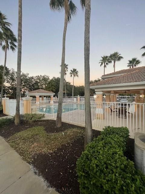 pool at dusk with a patio area