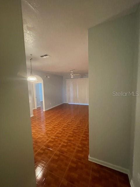 hall featuring dark tile patterned flooring