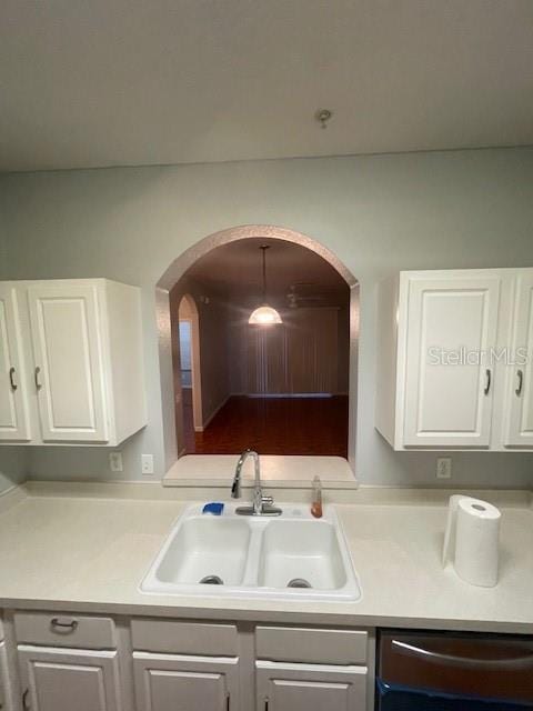 kitchen with pendant lighting, sink, stainless steel dishwasher, and white cabinets