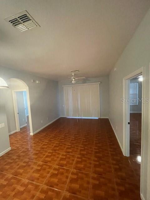 tiled spare room featuring ceiling fan