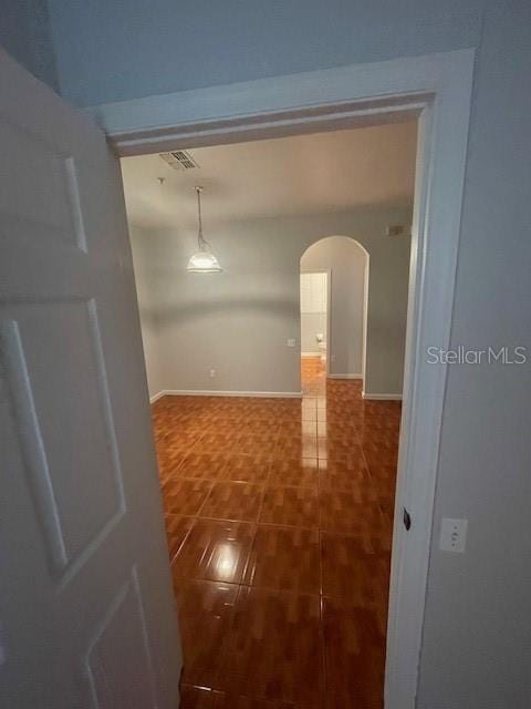 hall with dark tile patterned floors