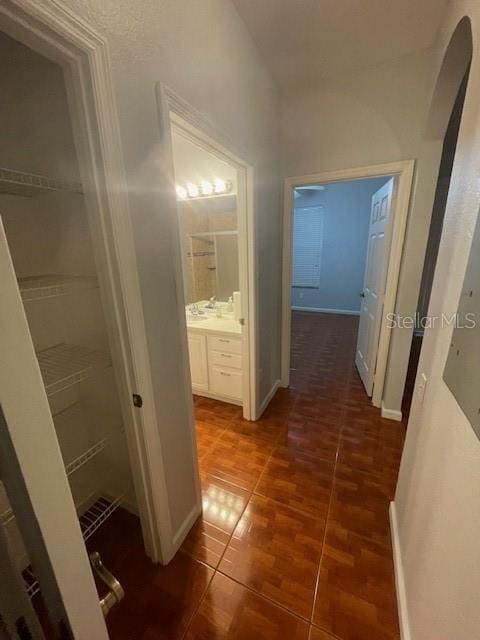 hallway featuring dark tile patterned floors