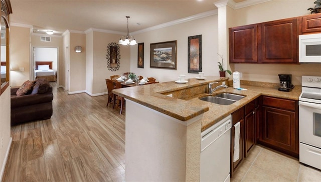 kitchen with kitchen peninsula, white appliances, crown molding, sink, and an inviting chandelier