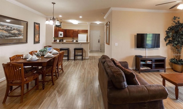 living room featuring ceiling fan with notable chandelier, light hardwood / wood-style floors, and ornamental molding