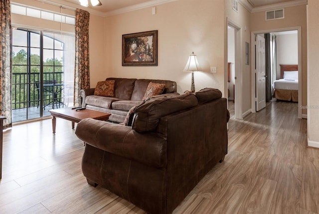 living room featuring crown molding and light hardwood / wood-style flooring