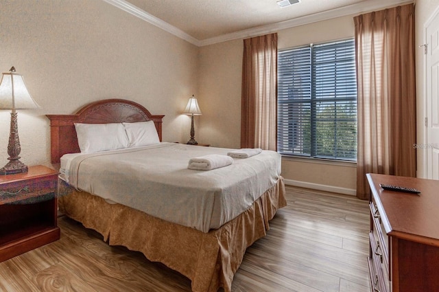 bedroom with light hardwood / wood-style flooring and ornamental molding