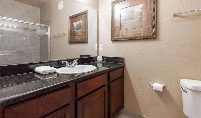 bathroom featuring vanity, toilet, and a shower with shower door