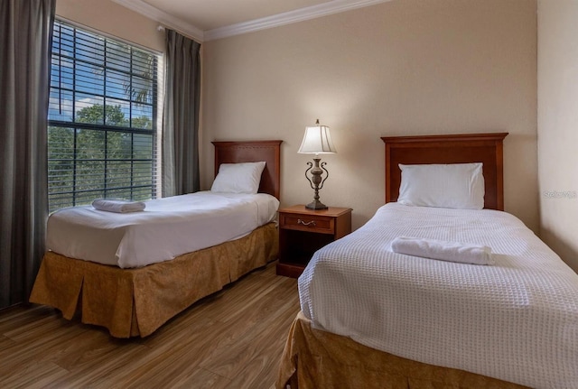 bedroom with wood-type flooring and ornamental molding