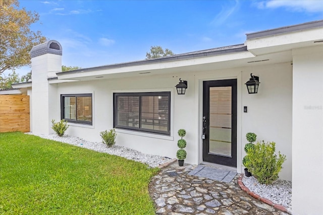 doorway to property with a yard