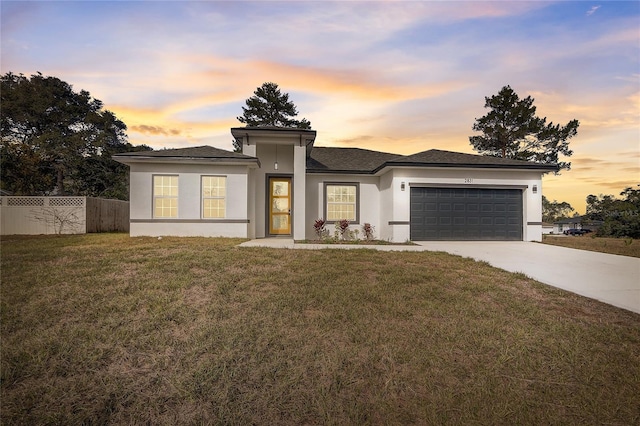 prairie-style home with a yard and a garage