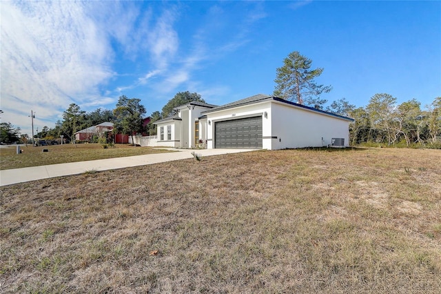 view of front of house featuring a front lawn, central AC unit, and a garage