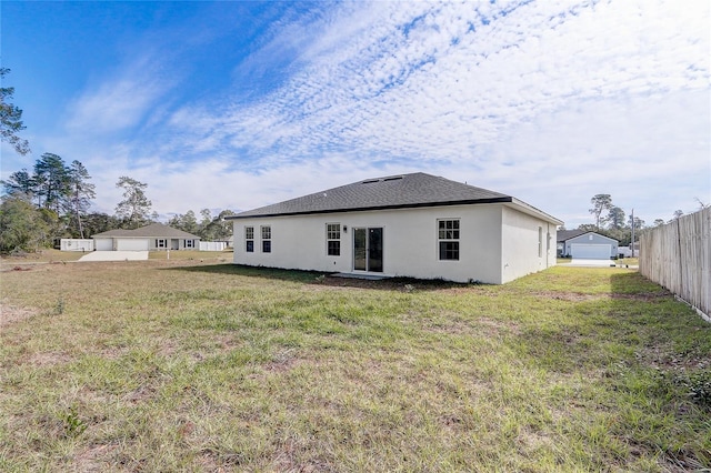 rear view of property with a garage and a yard