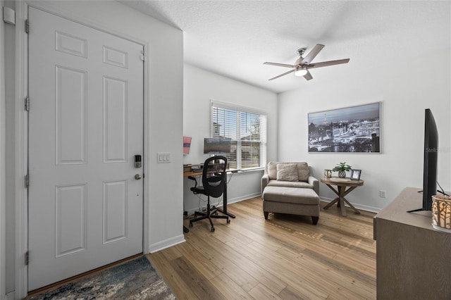 foyer featuring ceiling fan, light hardwood / wood-style floors, and a textured ceiling