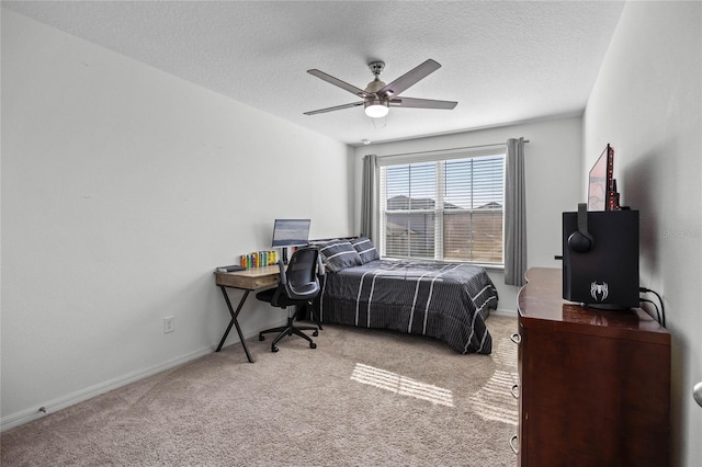 bedroom with ceiling fan, light colored carpet, and a textured ceiling