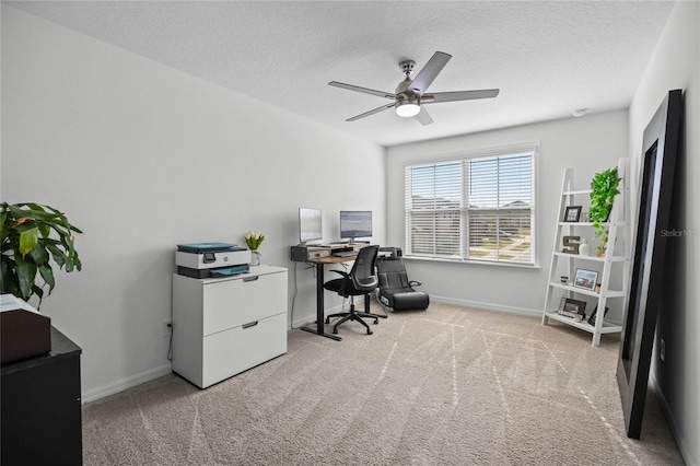 office space featuring ceiling fan, light colored carpet, and a textured ceiling