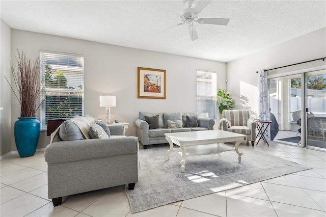 tiled living room with a wealth of natural light, ceiling fan, and a textured ceiling