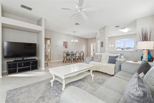 tiled living room featuring a textured ceiling and ceiling fan with notable chandelier