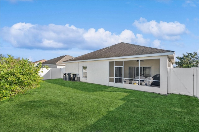 rear view of house with a yard and a sunroom