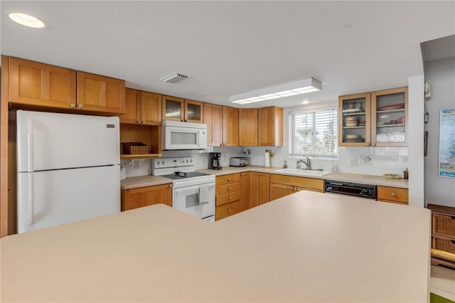 kitchen featuring white appliances, tasteful backsplash, and sink