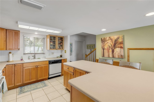 kitchen with stove, white dishwasher, sink, decorative backsplash, and light tile patterned floors