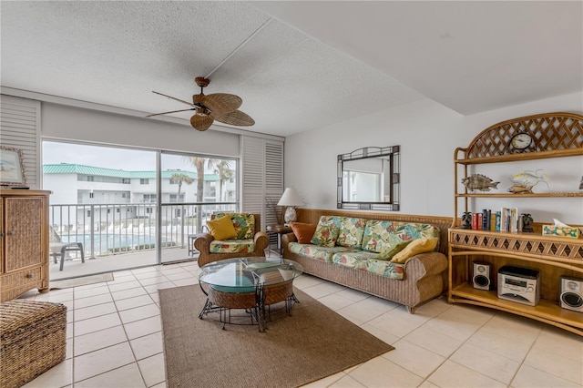 tiled living room with ceiling fan and a textured ceiling