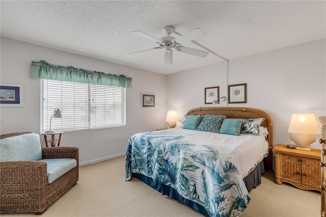 bedroom featuring light carpet, a textured ceiling, and ceiling fan