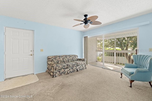 sitting room with carpet, ceiling fan, and a textured ceiling