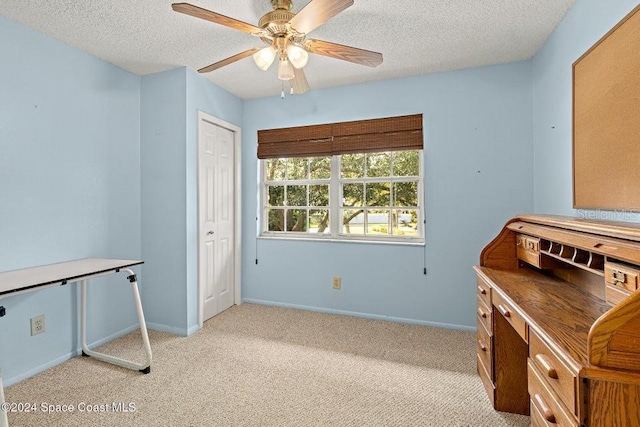 misc room with light carpet, ceiling fan, and a textured ceiling