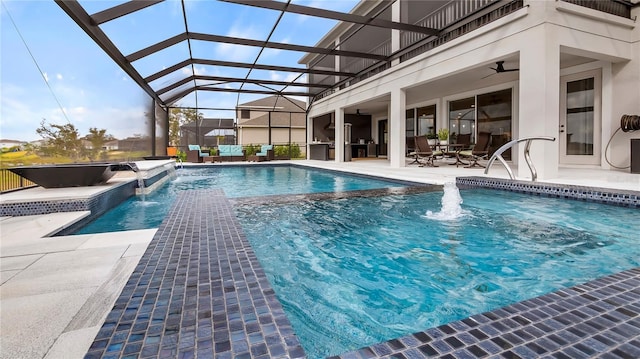 view of pool with ceiling fan, a lanai, pool water feature, and a patio area