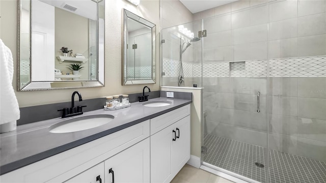 bathroom with an enclosed shower, vanity, and tile patterned floors