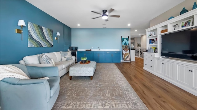 living room featuring ceiling fan, dark hardwood / wood-style flooring, and sink