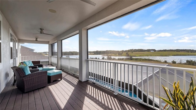 wooden deck featuring ceiling fan, outdoor lounge area, and a water view