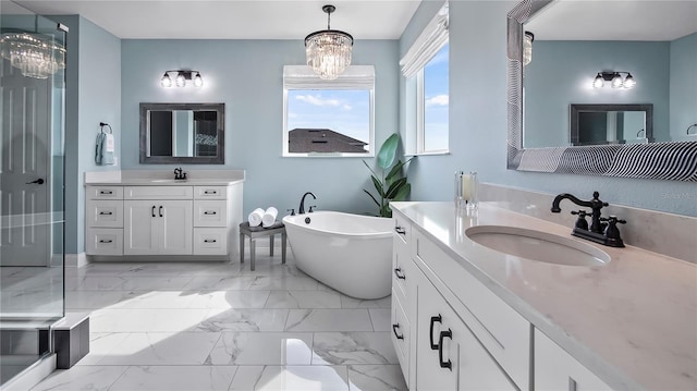 bathroom with vanity, an inviting chandelier, and a bathing tub