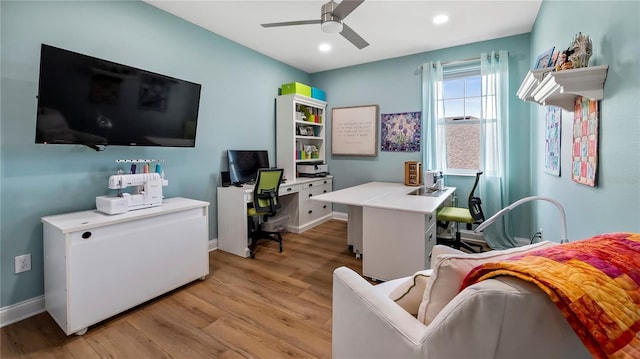 home office with light hardwood / wood-style floors and ceiling fan