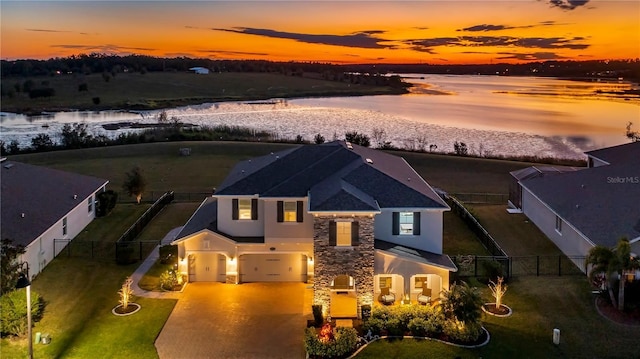 aerial view at dusk featuring a water view