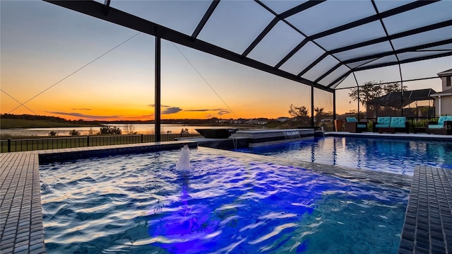 pool at dusk featuring pool water feature, a lanai, and a water view